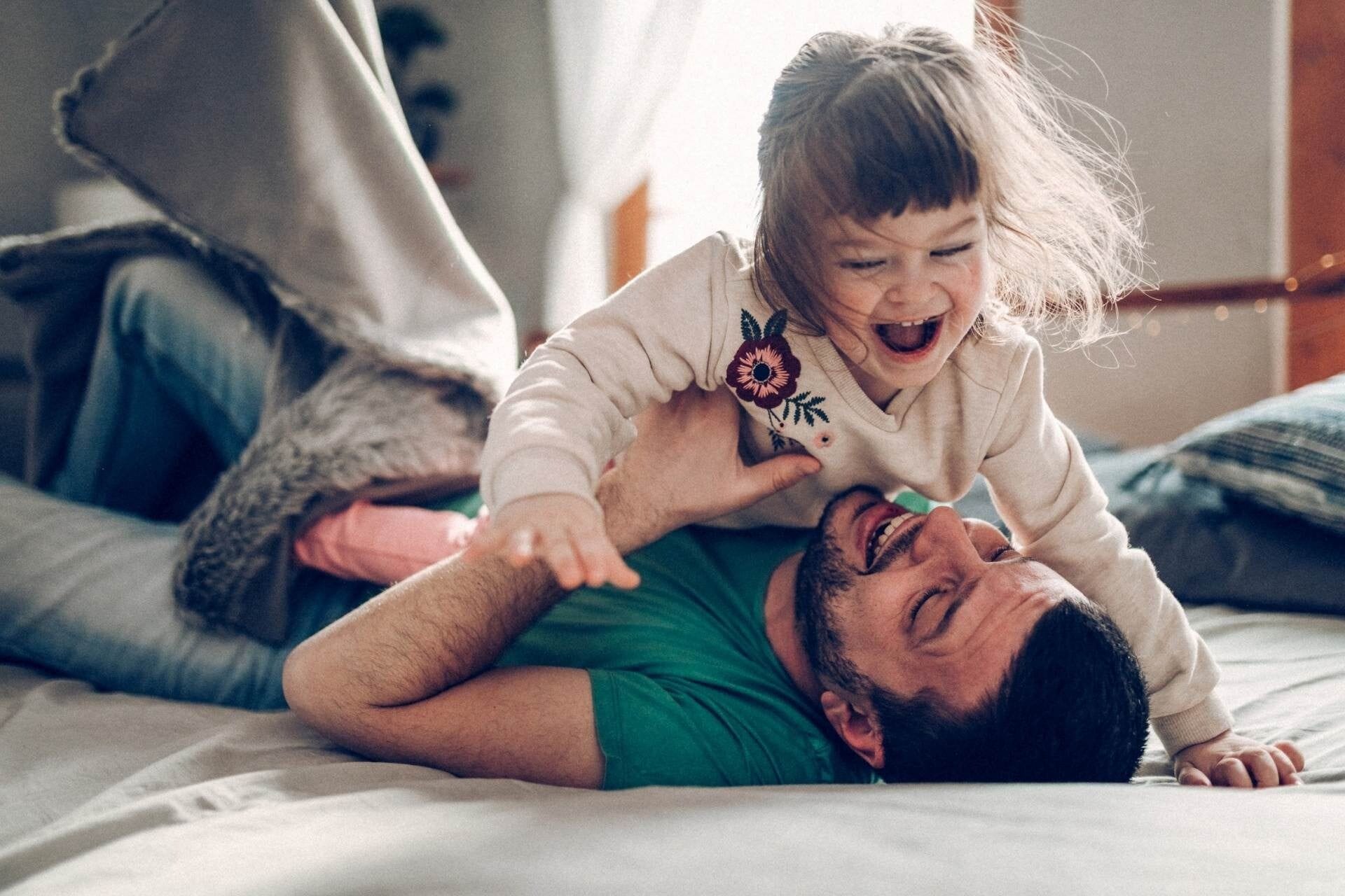 Happy family moments - father playing with daughter at home